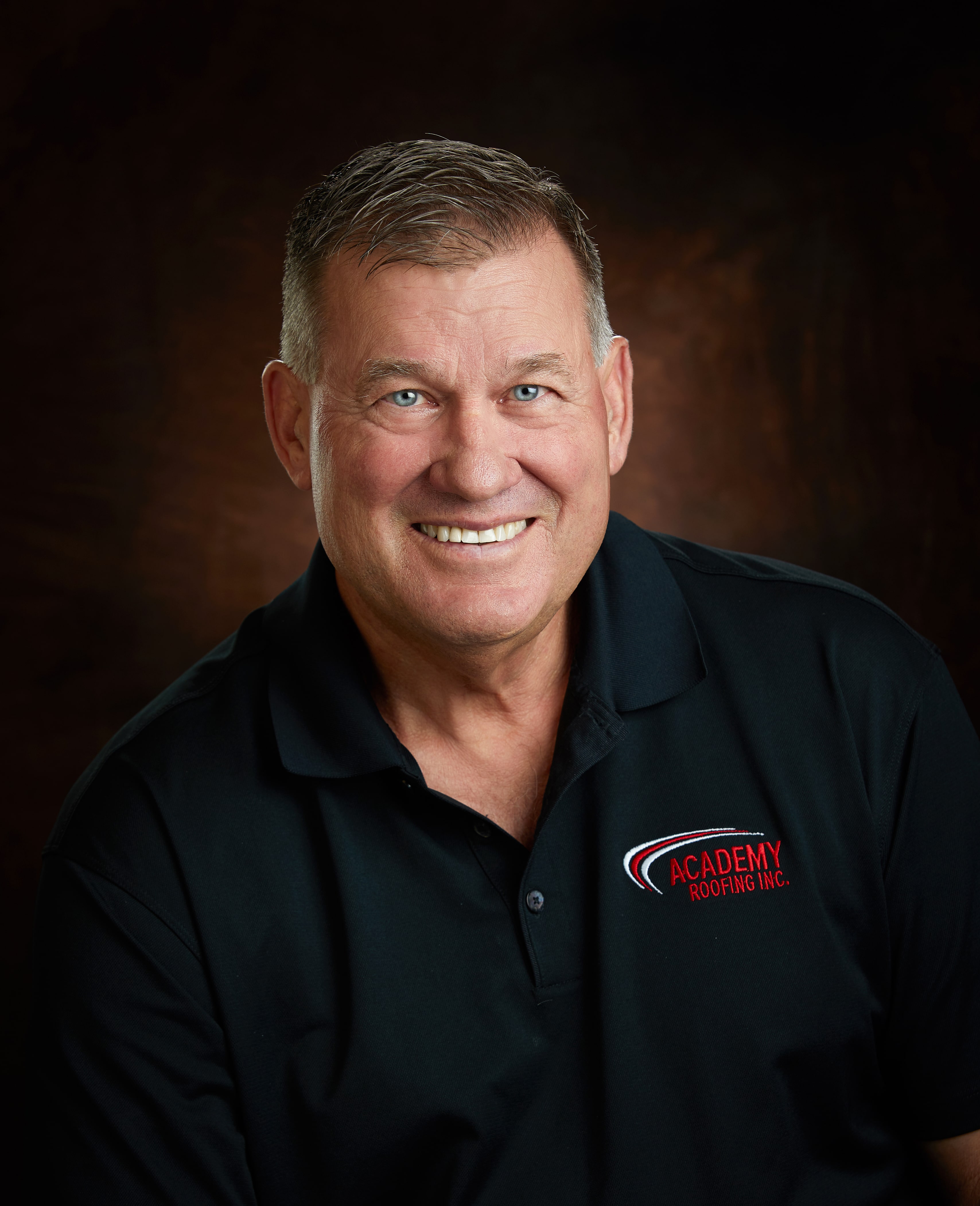 headshot of man wearing academy roofing polo