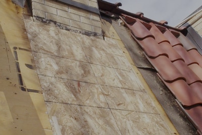roof in need of repair with damage from chimney