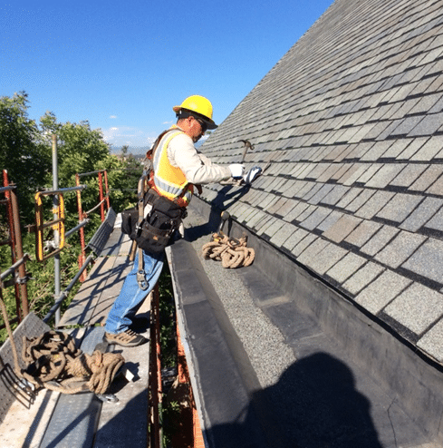 roofer with yellow hardhat working on roof